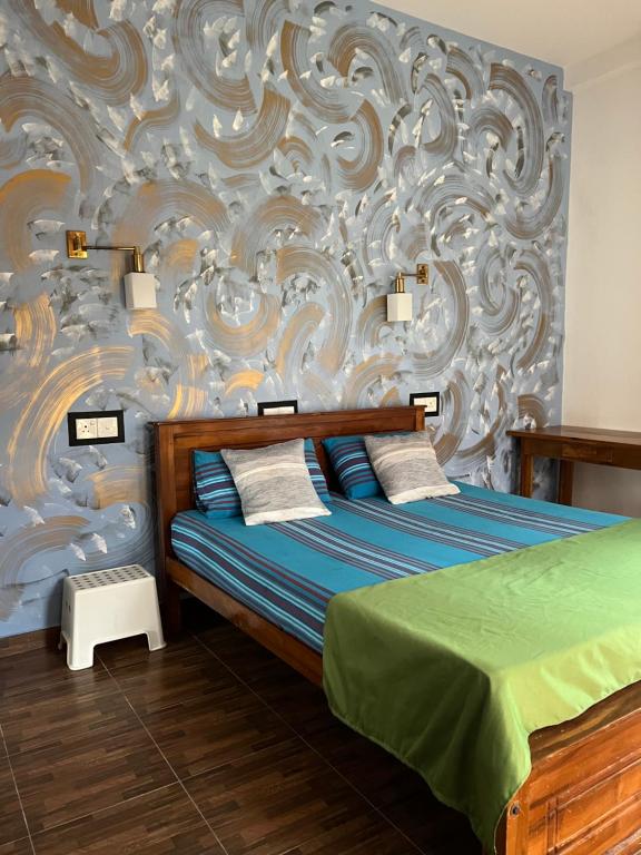 a bedroom with a bed and a wall with a mural at Ruwan Villa Ahangama in Ahangama