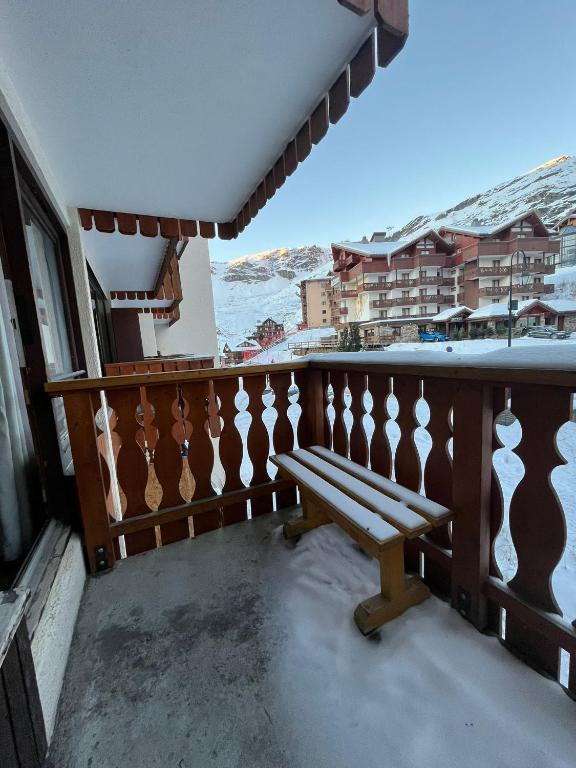 瓦托倫斯的住宿－Cosy Condo Ski-In Out Val Thorens，坐在阳台上的长椅上,上面有雪