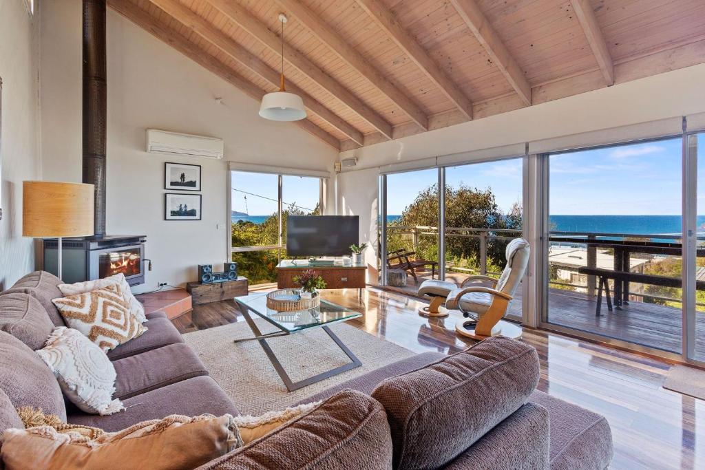 a living room with a couch and a view of the ocean at Otway Views in Apollo Bay