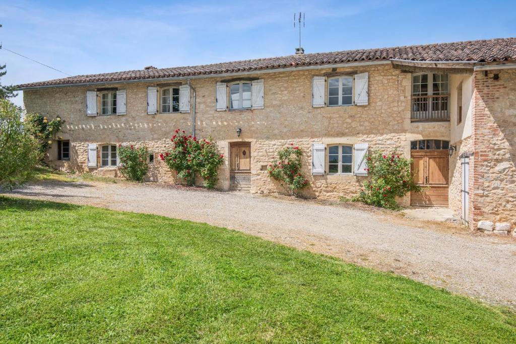 una vecchia casa in pietra con un cortile davanti di Villa spacieuse avec piscine privée, à Salies, 250 m², 6 chbres a Saliès