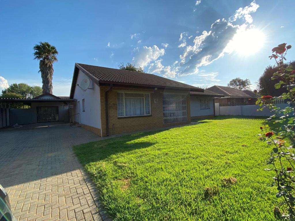 a house with a palm tree in the yard at Simbia Contractors Inn in Vaalpark