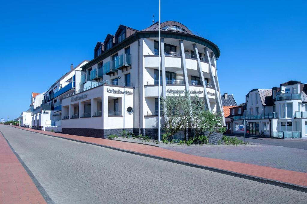een wit gebouw aan de straatkant bij Michels Villa Nordsee in Norderney