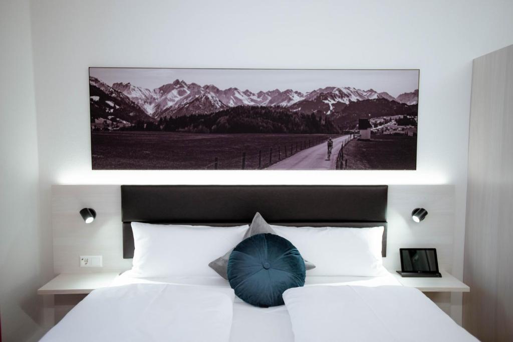 sypialnia z łóżkiem z niebieskim parasolem w obiekcie Reos Hotel Wangen w mieście Wangen im Allgäu