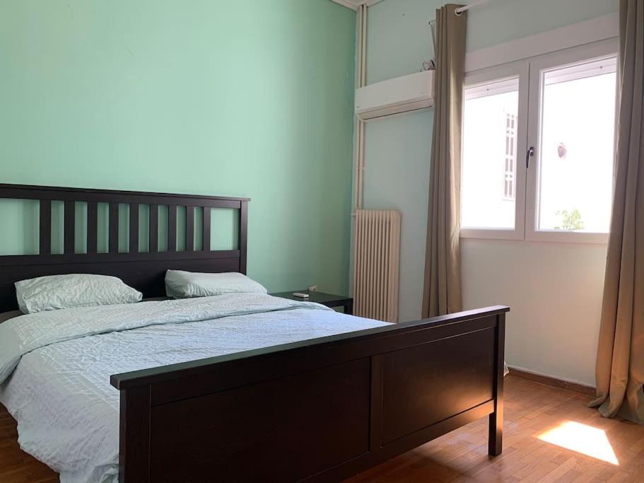 a bedroom with a large bed and a window at 2 bedroom apartment 300 meters metro Aghios loanis in Athens