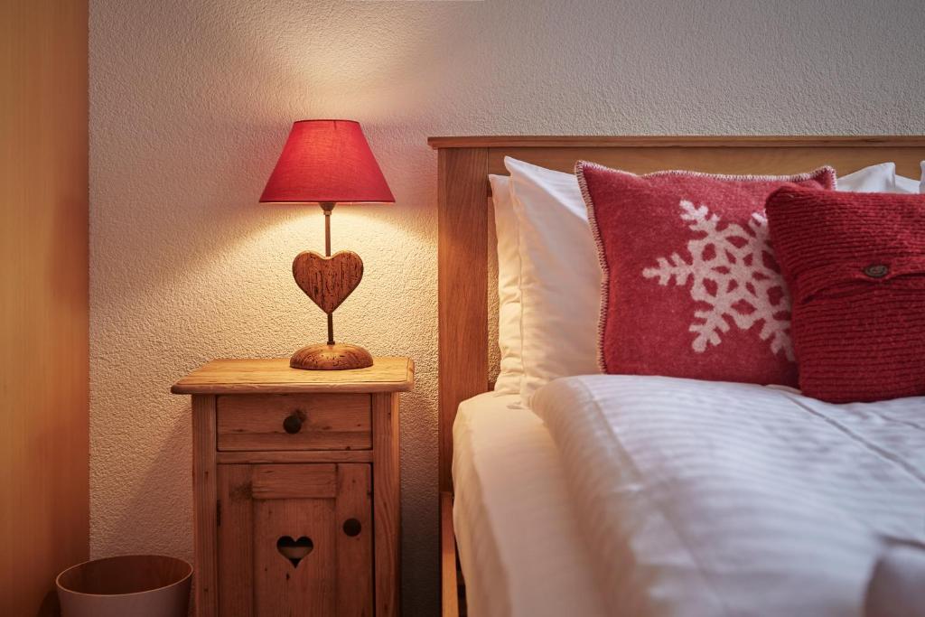 ヴェンゲンにあるChalet Soleの木製の寝台に赤いランプが付いたベッド