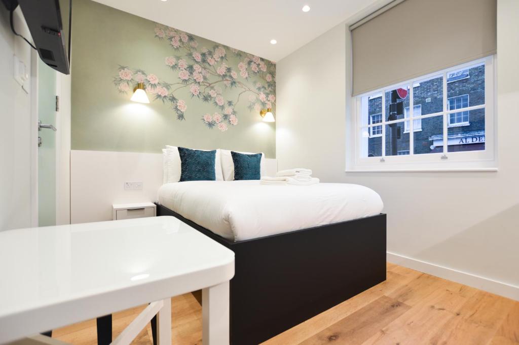 1 Schlafzimmer mit 2 Betten und einem Fenster in der Unterkunft Sale Place Serviced Apartments by Concept Apartments in London