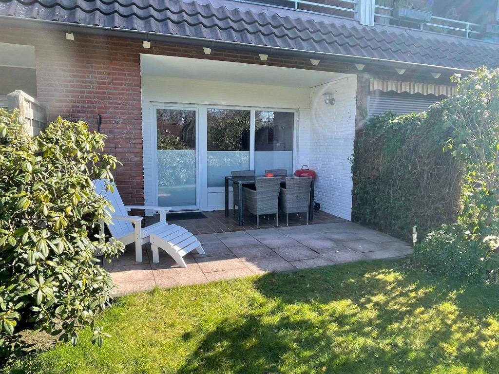 een patio met een tafel en stoelen in een tuin bij Appenzeller, S u A , Ferienwohnung Dangaster Tied 2 in Dangast