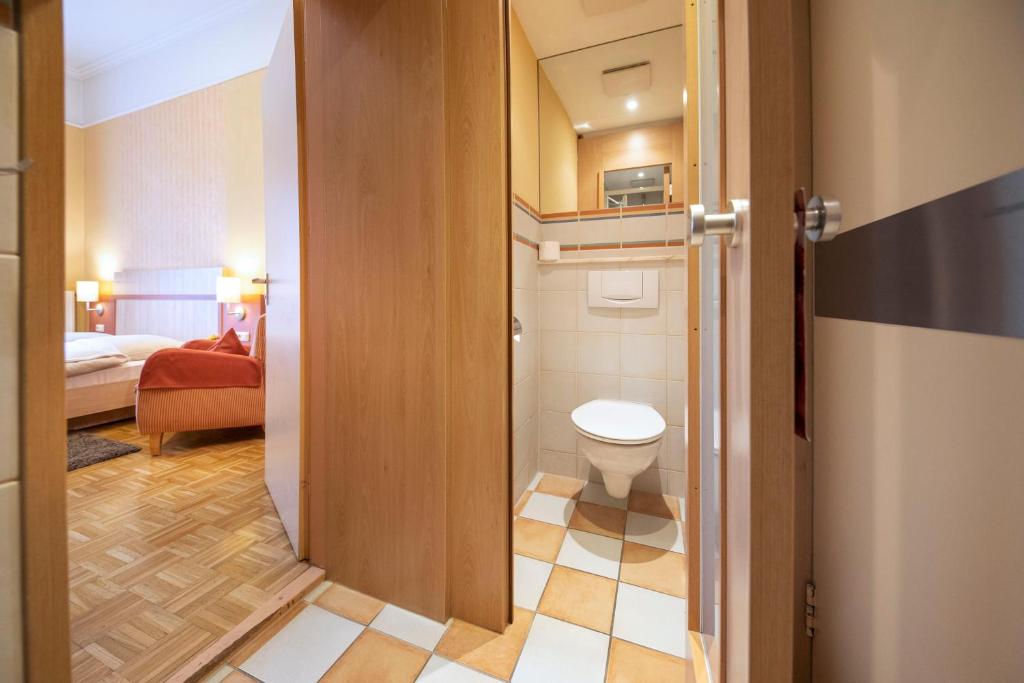 a small bathroom with a toilet in a room at ACHAT Sternhotel Bonn in Bonn