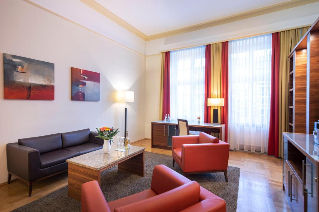 a living room with a couch and chairs and a table at ACHAT Sternhotel Bonn in Bonn