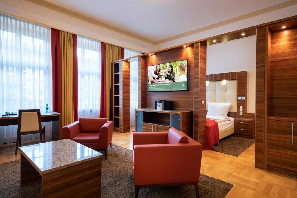 a hotel room with a bed and a living room at ACHAT Sternhotel Bonn in Bonn