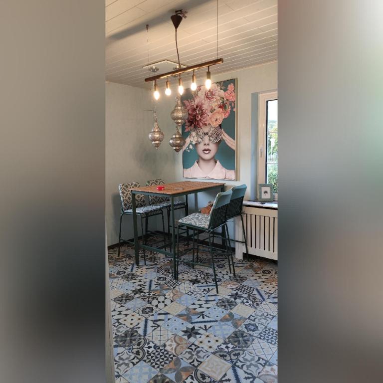 une salle à manger avec une table, des chaises et une photo dans l'établissement Ferienvilla, à Eppelborn