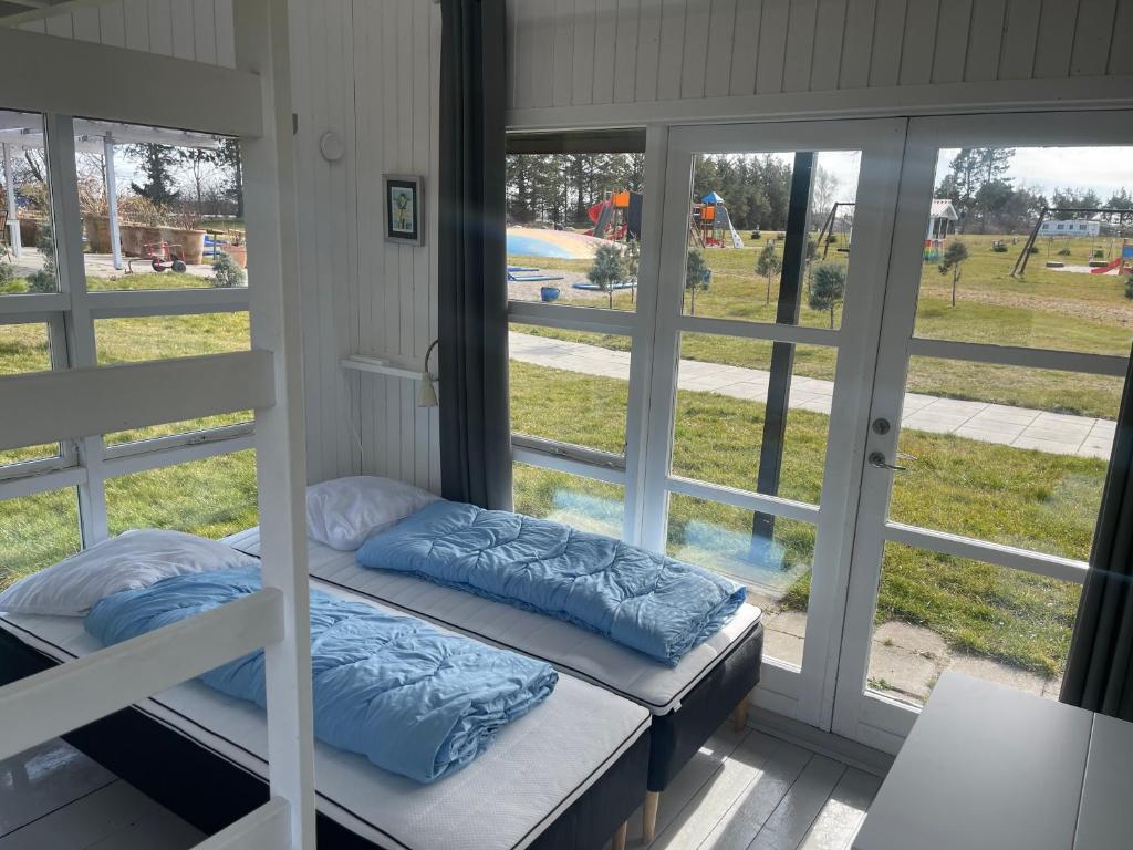 een kamer met 2 stapelbedden en een raam bij Tisvildeleje Camping Hytter in Vejby