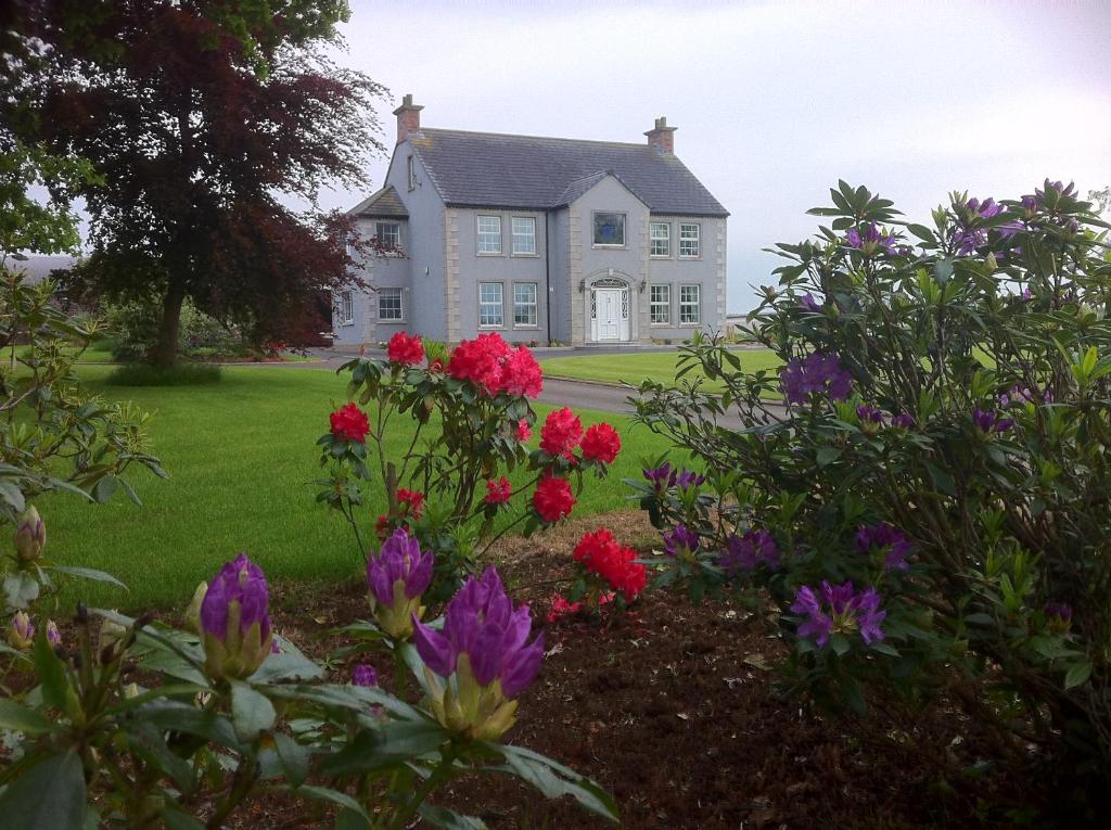 una casa con flores delante en Ballyharvey B&B, en Antrim
