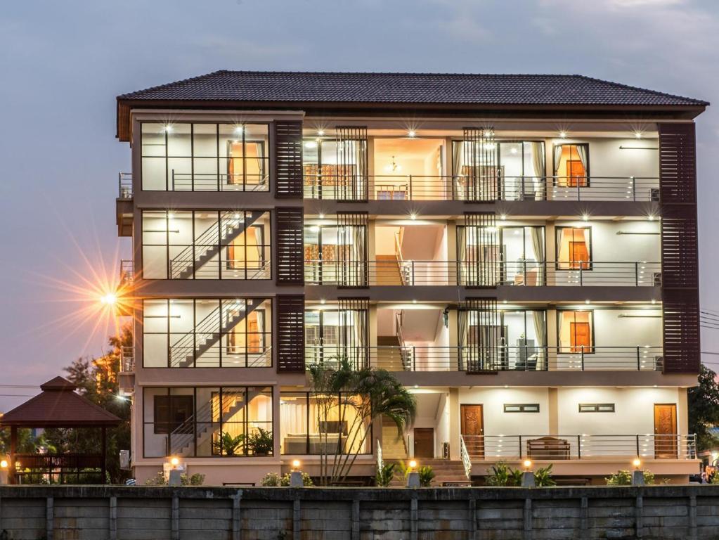 an apartment building with a lit up facade at night at Onvara Place in Phra Nakhon Si Ayutthaya