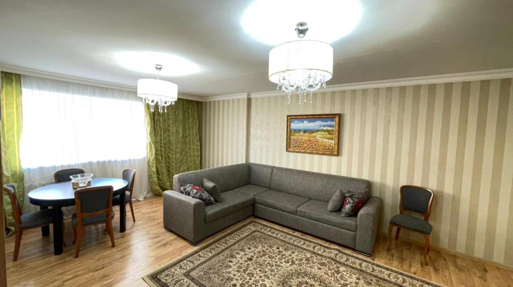 a living room with a couch and a table at На Тархана in Astana