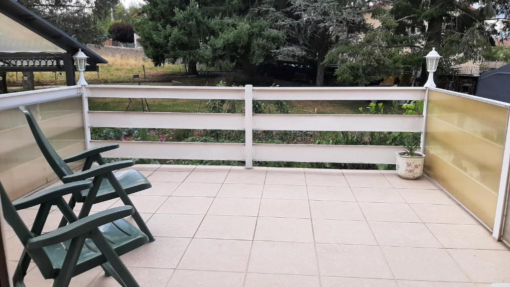 a white fence with two chairs on a patio at Charmant Logement T2 campagne 