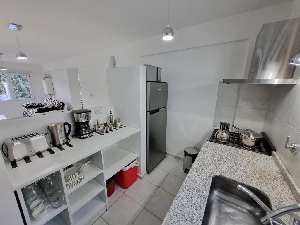 a kitchen with a sink and a refrigerator at Bariloche Modern Apartment Belgrano in San Carlos de Bariloche