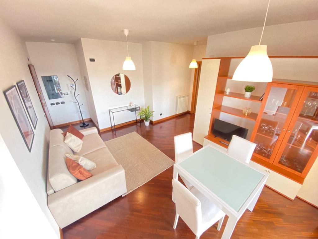 a living room with a white couch and a table at Casa Relax con Terrazza Panoramica in Fiumicino