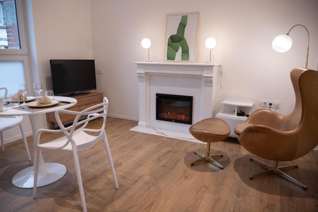 a living room with a fireplace and a table and chairs at au42dotBzh in Saint-Brieuc