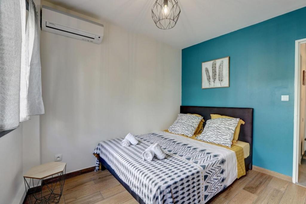 1 dormitorio con 1 cama con pared azul en Le Zévi - appt T2 Saint Denis en Saint-Denis