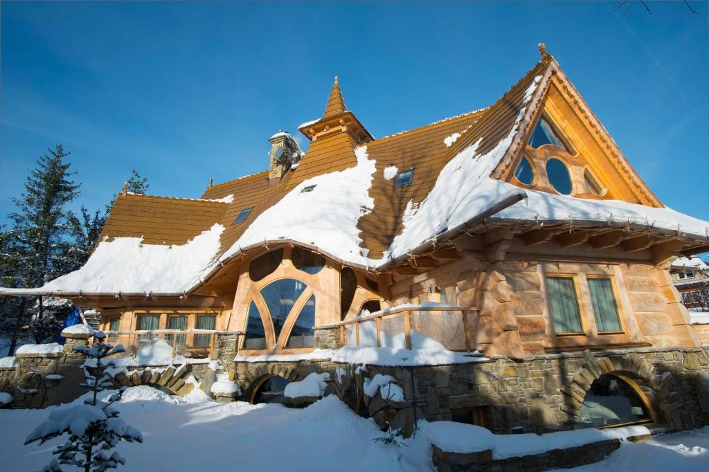 a log cabin with snow on the roof at Villa Belweder in Zakopane