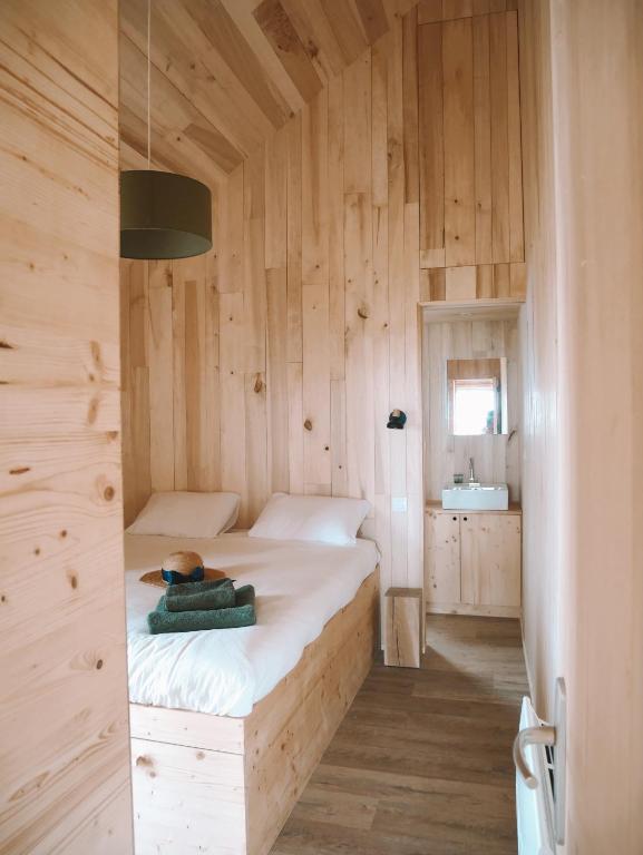 a bedroom with a bed in a wooden wall at Domaine St-Amand in Saint-Amand-de-Coly