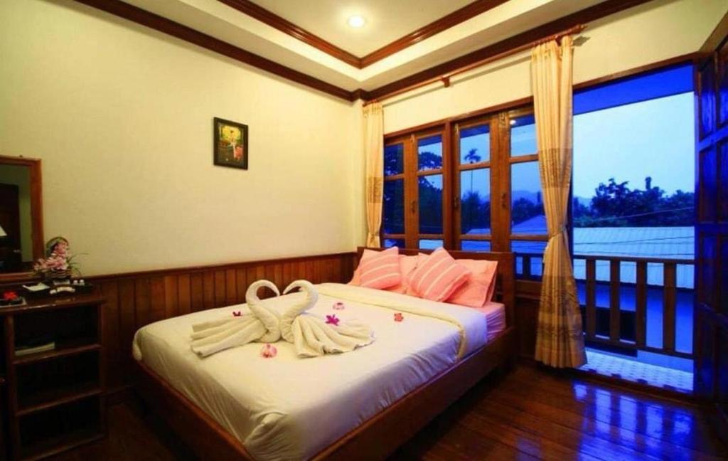 a bedroom with a bed with towels on it at สุขนิรันดร์​ริมโขง in Chiang Khan