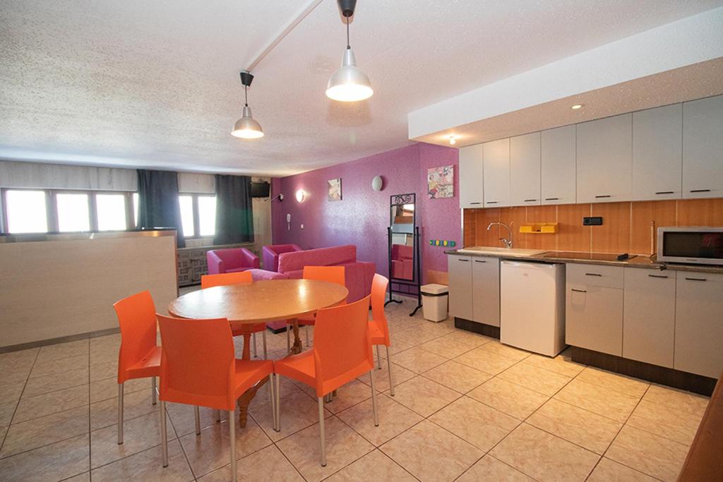 - une cuisine et une salle à manger avec une table et des chaises dans l'établissement Apartaments Turistics Natural Suites Manzano 3000, au Pas de la Case