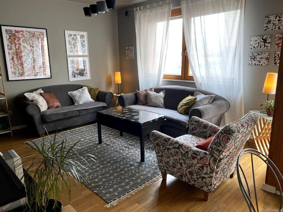een woonkamer met een bank en 2 stoelen bij Artist's Apartment in Prishtina in Pristina