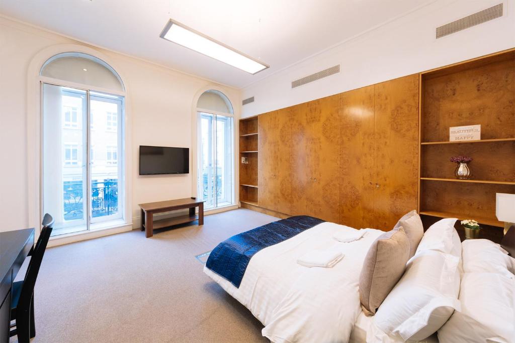 sypialnia z dużym łóżkiem i telewizorem w obiekcie Curzon Residences w Londynie