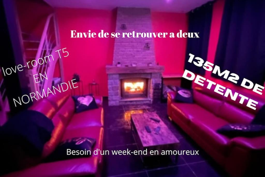 um quarto com um sofá e uma lareira com luzes cor-de-rosa em Au nid d'amour em Bellencombre