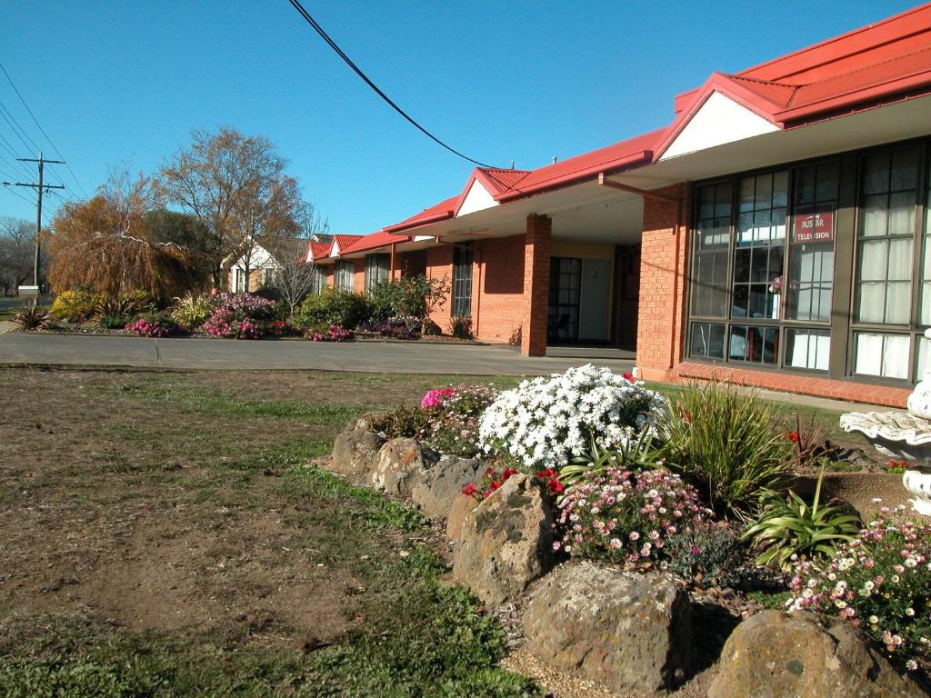 a building with a bunch of flowers in front of it at Ambassador Motor Inn in Ballarat