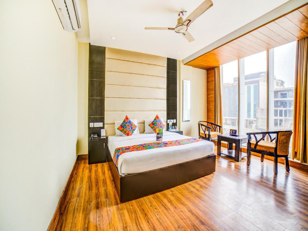 a bedroom with a king sized bed and a table at FabHotel Diamond Zirakpur in Zirakpur