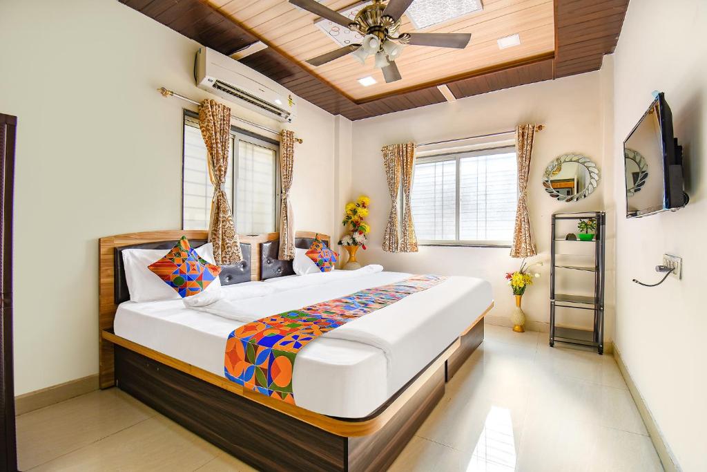 a bedroom with a large bed and a ceiling fan at FabExpress Vardhan Executive in Pune