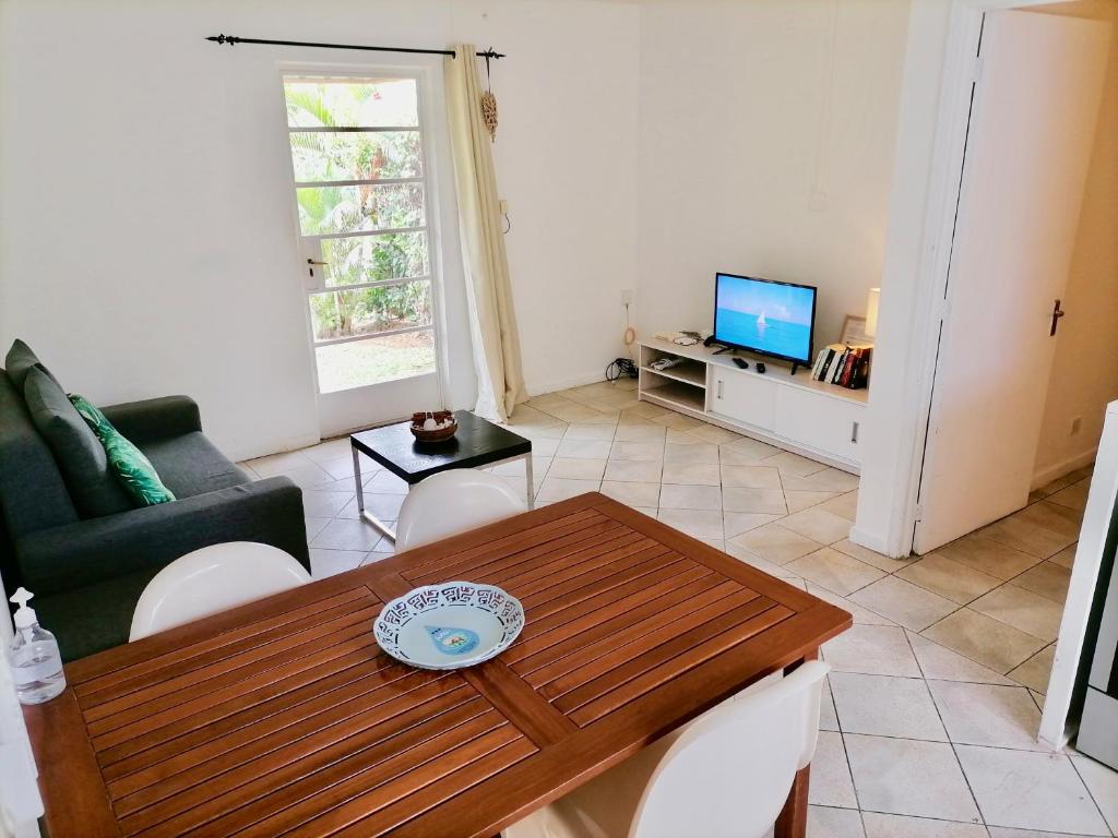 a living room with a table and a television at Beachfront 2 Bedroom-house - Tilacaze in Flic-en-Flac