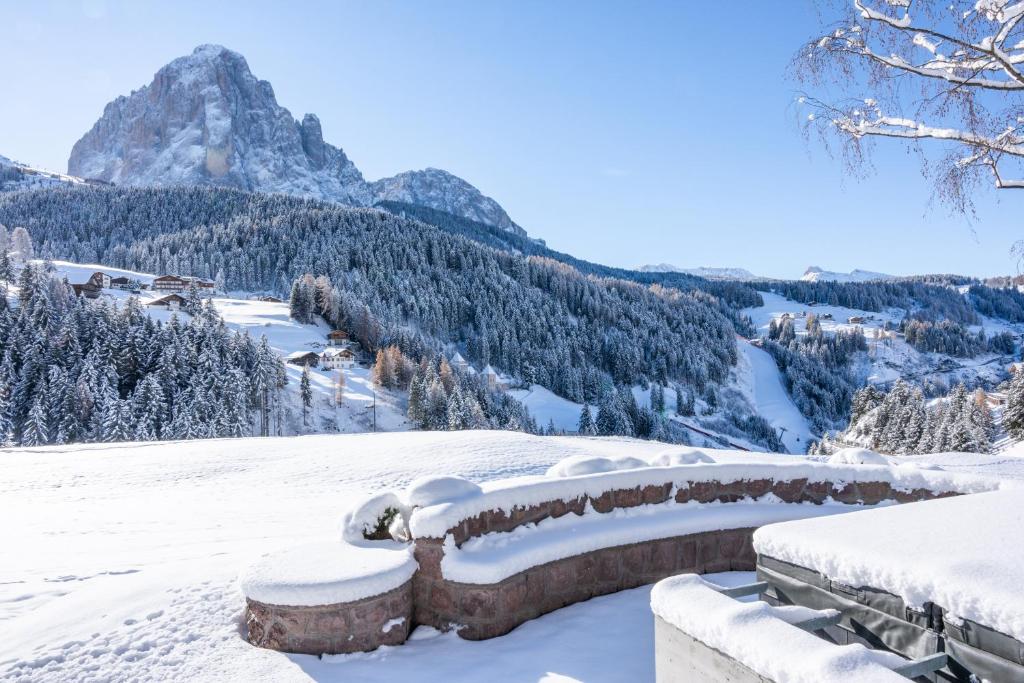 a snow covered hill with a mountain in the background at Chalet Villa Carolina in Selva di Val Gardena