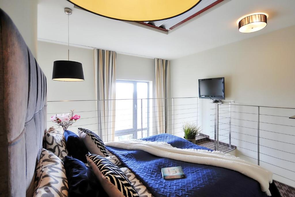 1 dormitorio con 1 cama con edredón azul en DOBRUK APARTAMENTY Roma apartament prywatny w pięciogwiazdkowym hotelu Royal Tulip Sand, en Kołobrzeg
