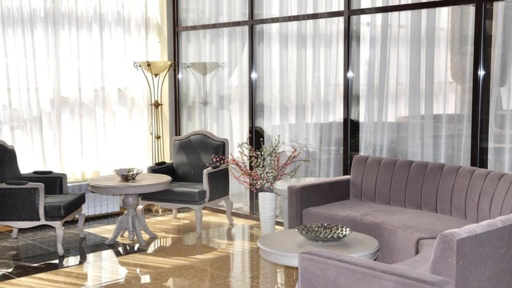 阿特勞的住宿－Reikartz Sunkar Atyrau，客厅配有沙发、椅子和桌子