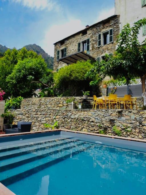 une piscine devant un immeuble dans l'établissement Authentique Maison de Village Corse Vue mer, à Santa-Maria-Poggio