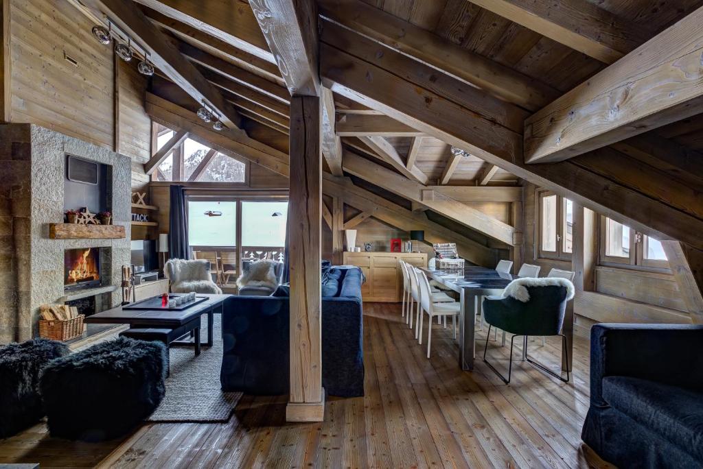 sala de estar con techos de madera y comedor en Luxurious Ski-in Ski-out Duplex on Ski Slope, en Courchevel
