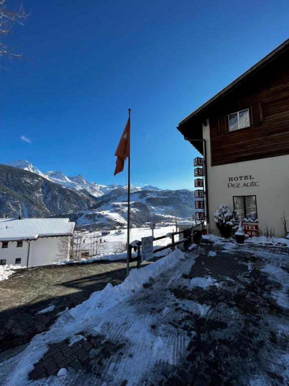 un edificio con una bandera en la nieve en Hotel Péz Ault, en Disentis