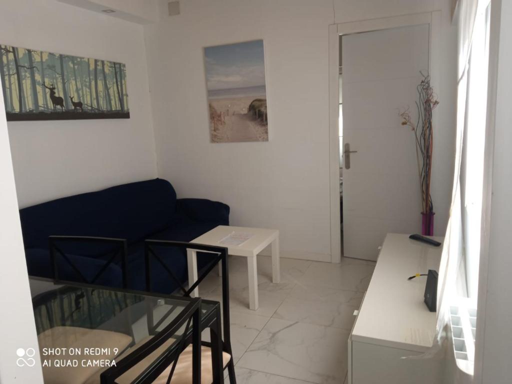 a living room with a blue couch and a table at Apartamento céntrico en Villaviciosa de Odon in Villaviciosa de Odón