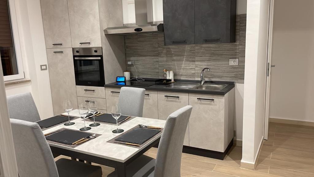 a kitchen with a table with chairs and a sink at B&B MANFREDI in Foggia