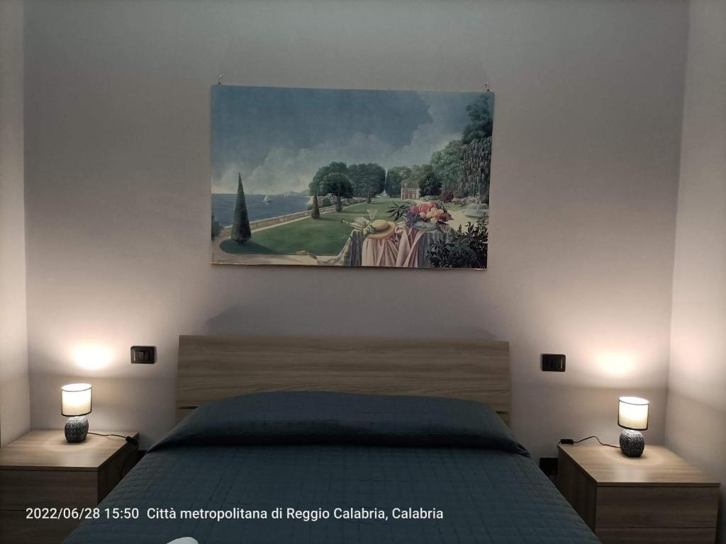 a painting hanging above a bed in a bedroom at nonna rosa in Reggio Calabria