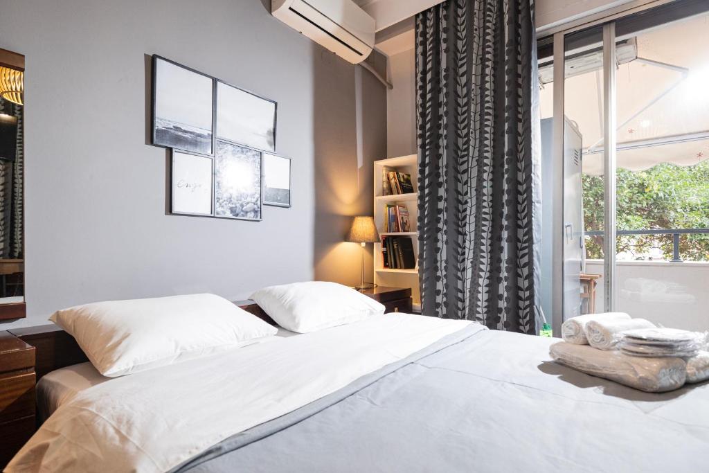 ein Schlafzimmer mit einem weißen Bett und einem Fenster in der Unterkunft Delmare Posidonio Apartment in Thessaloniki