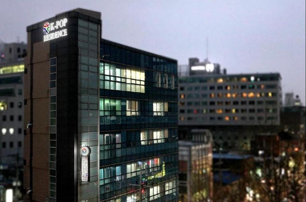 un grand bâtiment avec un panneau sur son côté dans l'établissement Hostel Kpop, à Séoul