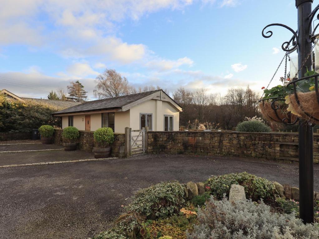 a house with a stone fence and a yard at Swallow cottage, Over Kellet in Over Kellet