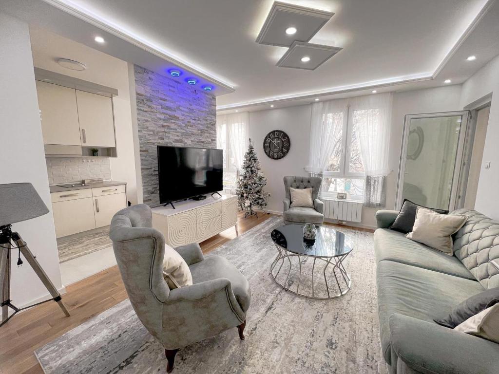 a living room with two couches and a flat screen tv at Fontana apartmani FREE parking in Tuzla