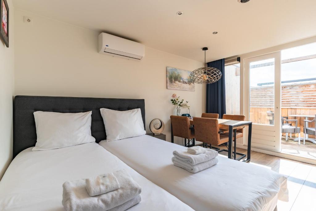 a bedroom with a bed and a dining room at Stylish apartments in the heart of Breda city center in Breda