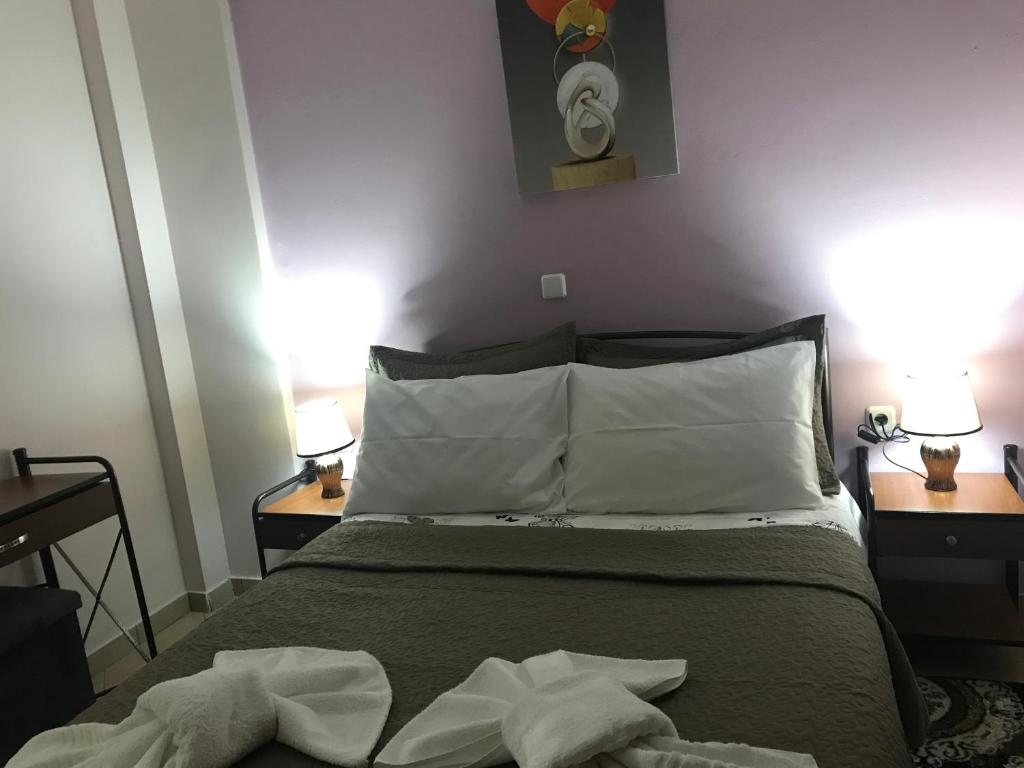 a bedroom with a bed with white sheets and pillows at GERASIMOS HOYSE in Vitina